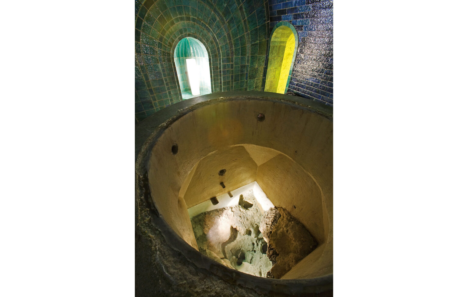 Klares Wasser im Blick von oben; am Grund schimmert die ursprüngliche eckige Quellfassung.